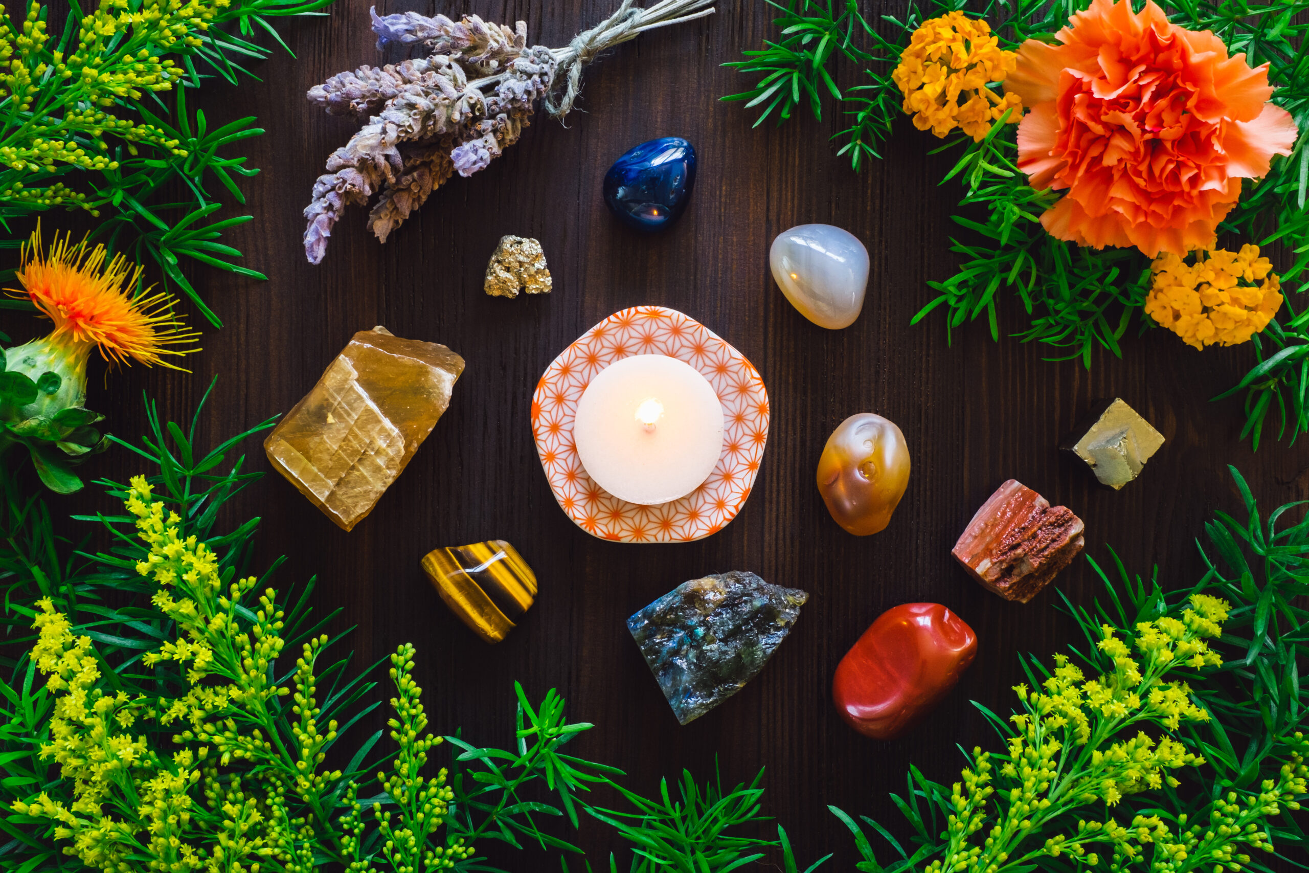 Lit Candle with Stones and Flowers of Summer, including Agate, Honey Calcite, Red Jasper, Labradorite and Pyrite