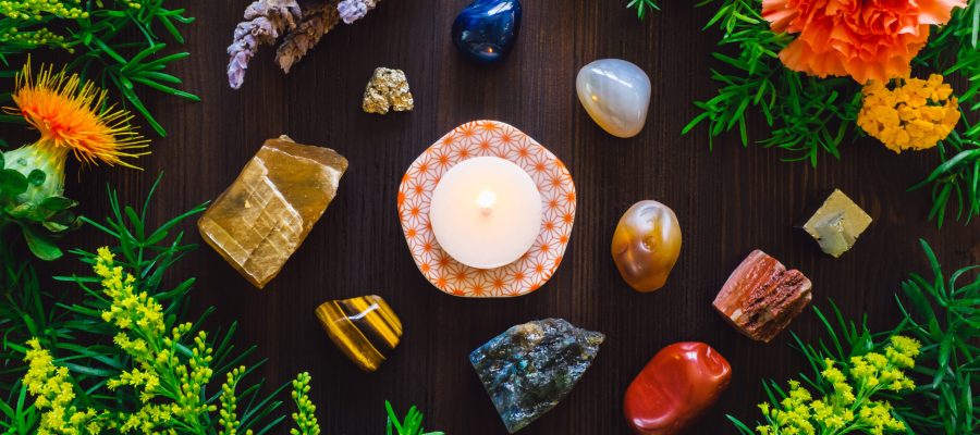 Lit Candle with Stones and Flowers of Summer, including Agate, Honey Calcite, Red Jasper, Labradorite and Pyrite