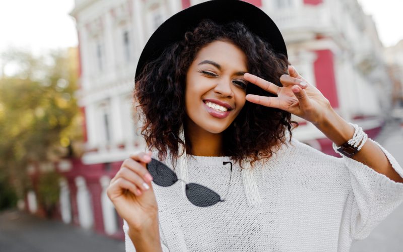 Cute black woman posing outdoor. Showing signs and smiling. Happy emotions. fashion look. Traveling girl.